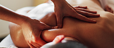person receiving a massage with hands applying pressure on the back for relaxation and tension relief two hands helping to ease stress
