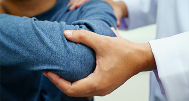 medical professional providing shoulder treatment to patient during therapy session