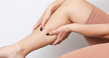 person holding their leg to relieve discomfort healthy leg maintenance and care