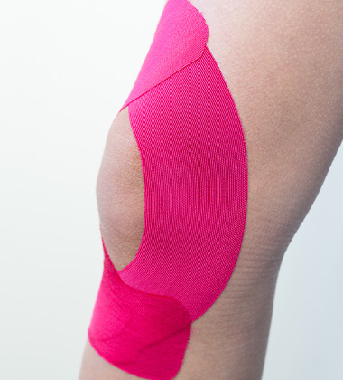 pink kinesiology tape applied to elbow for support and recovery
